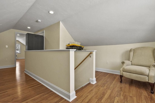 living area featuring recessed lighting, wood finished floors, an upstairs landing, baseboards, and vaulted ceiling