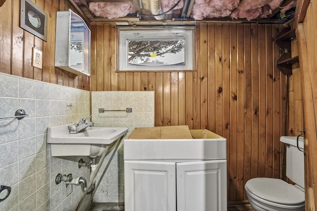 half bathroom featuring wood walls and toilet