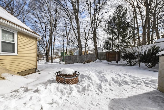 yard covered in snow featuring fence