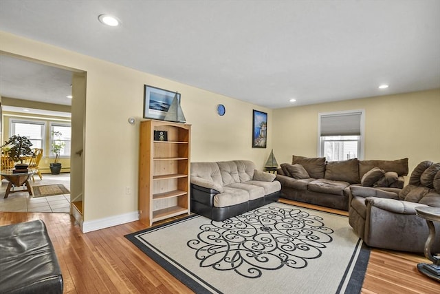 living area featuring baseboards, wood finished floors, a wealth of natural light, and recessed lighting