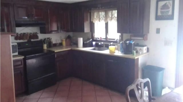 kitchen with light tile patterned flooring, black electric range, sink, and range hood