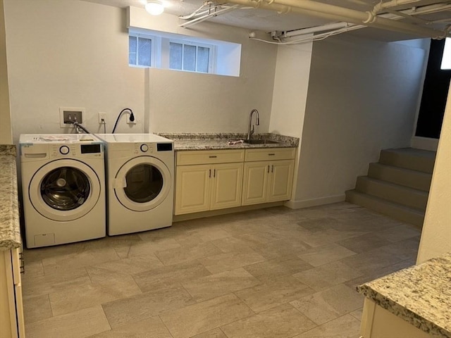 washroom featuring washer and dryer, sink, and cabinets