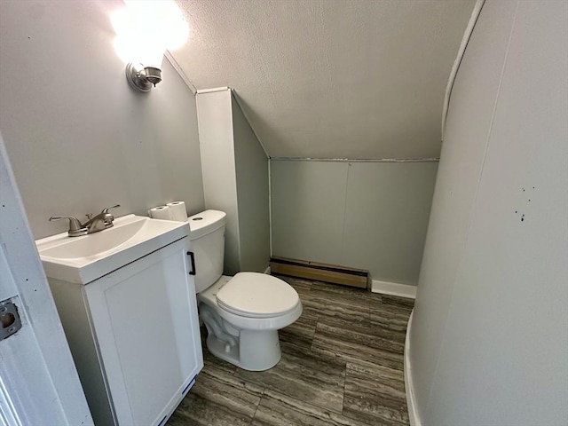 203 Division St, Fall River, MA 02721 - half bath featuring a baseboard heating unit, toilet, vanity, a textured ceiling, and vaulted ceiling