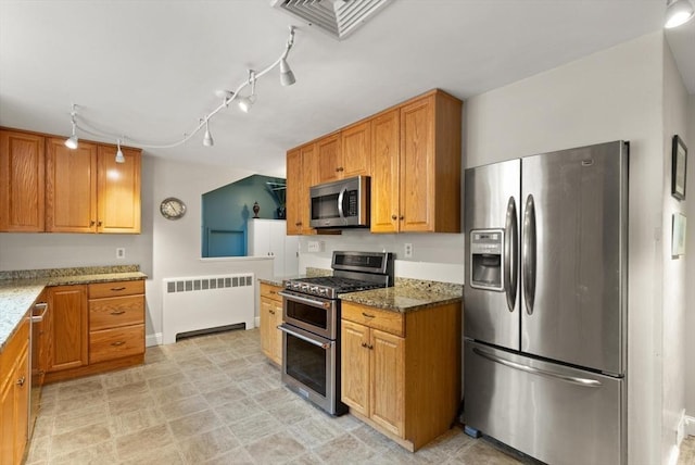 29 Day Ave, Hamilton, MA 01982 - kitchen with appliances with stainless steel finishes, radiator, light stone counters, track lighting, and brown cabinets