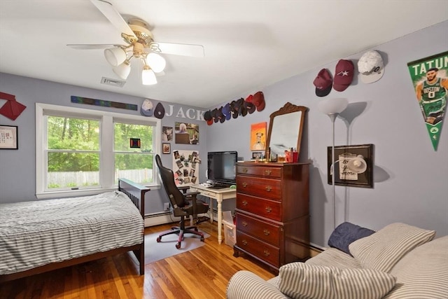 29 Day Ave, Hamilton, MA 01982 - bedroom featuring wood finished floors, a desk, a baseboard heating unit, and ceiling fan