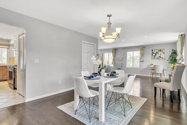 dining space featuring baseboards, recessed lighting, wood finished floors, and a chandelier