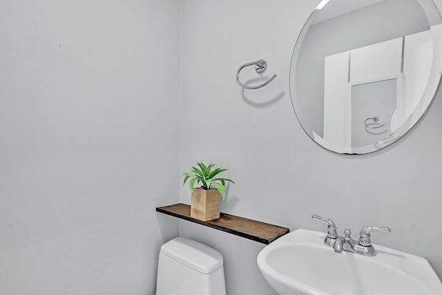 half bath with toilet and a sink
