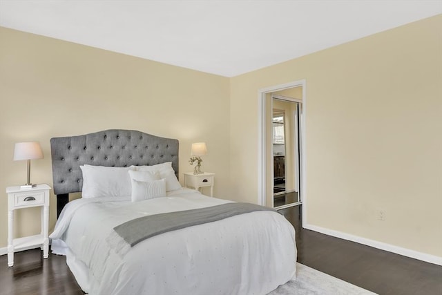 bedroom featuring baseboards and dark wood-type flooring