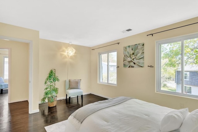 bedroom with visible vents, baseboards, dark wood-style floors, and multiple windows