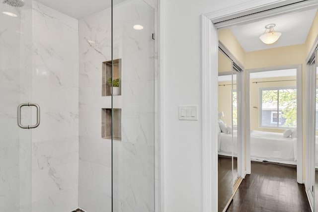ensuite bathroom with wood finished floors, a marble finish shower, and ensuite bath