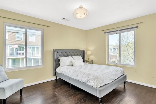 bedroom with baseboards, visible vents, and dark wood-style floors