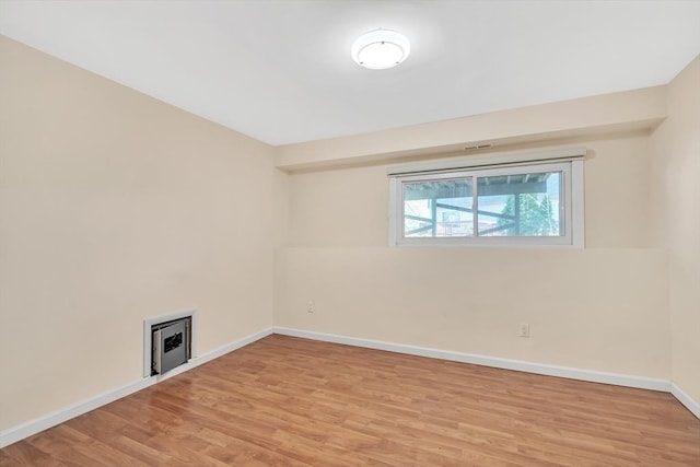 unfurnished room featuring baseboards and light wood-type flooring