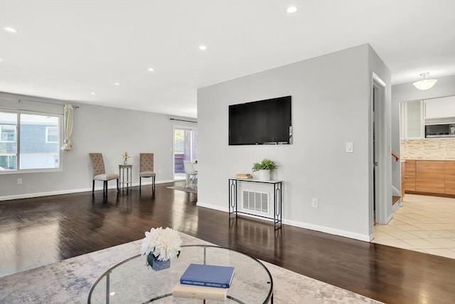 living area featuring baseboards, recessed lighting, and wood finished floors
