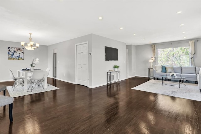 living room with recessed lighting, baseboards, wood finished floors, and a notable chandelier