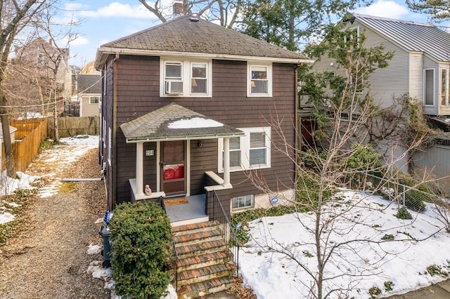 view of front of home with a shingled roof, cooling unit, fence, and a chimney