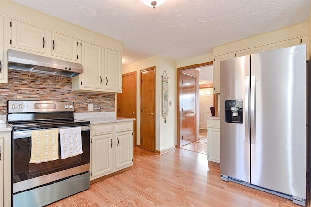 75 Columbus Ave Unit 75, Waltham, MA 02451 - kitchen with appliances with stainless steel finishes, under cabinet range hood, light wood-style flooring, decorative backsplash, and a textured ceiling