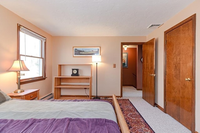 75 Columbus Ave Unit 75, Waltham, MA 02451 - bedroom with baseboard heating, baseboards, carpet flooring, a textured ceiling, and a closet