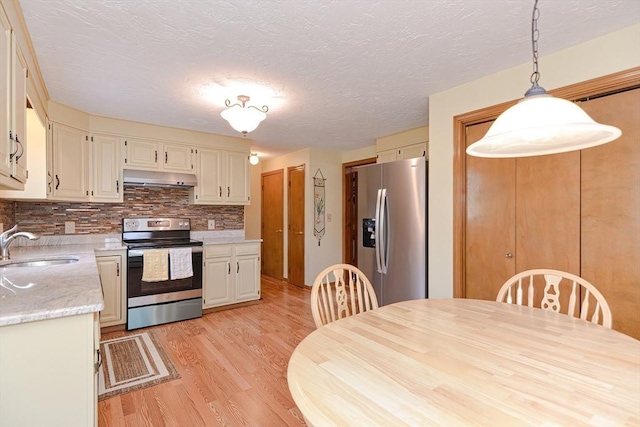 75 Columbus Ave Unit 75, Waltham, MA 02451 - kitchen with stainless steel appliances, under cabinet range hood, light wood-style flooring, a sink, and light countertops