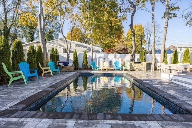 view of pool featuring a fenced in pool, a patio, exterior kitchen, and fence