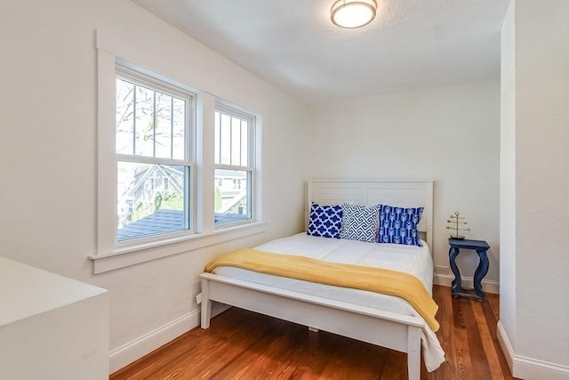 bedroom with baseboards and wood finished floors