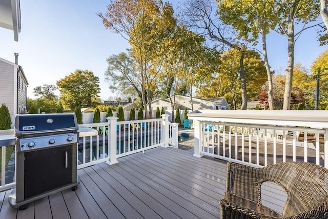 wooden terrace featuring a pool and grilling area