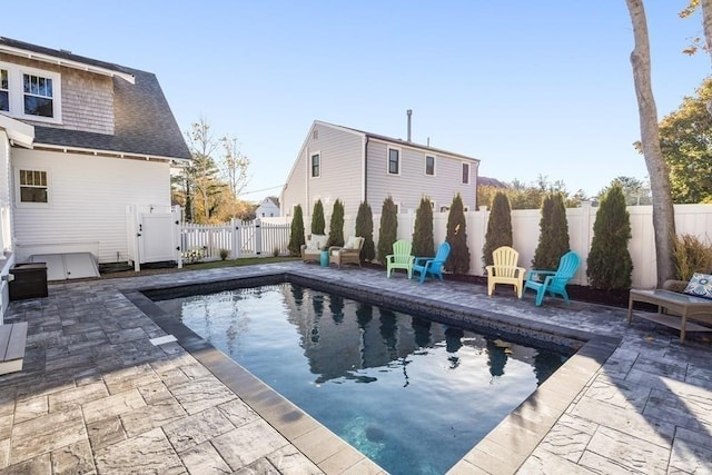 view of swimming pool featuring a patio area, a fenced in pool, a fenced backyard, and a gate