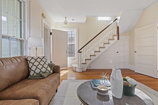 living room featuring stairway, baseboards, and wood finished floors