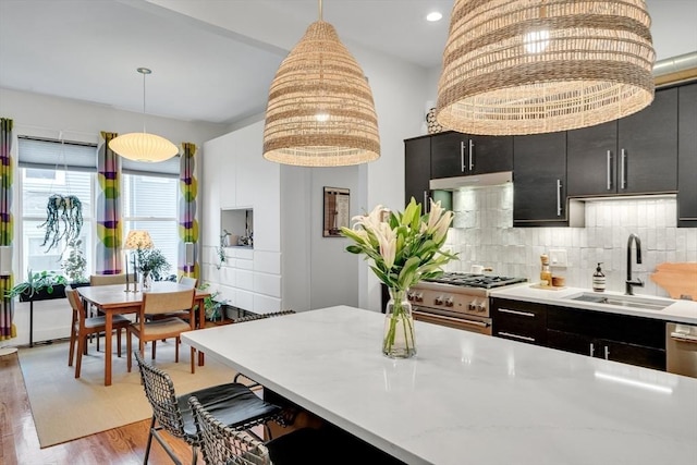 5 Mendell Way Unit 1, Boston, MA 02130 - kitchen featuring high end range, dark cabinetry, pendant lighting, light countertops, and a kitchen bar
