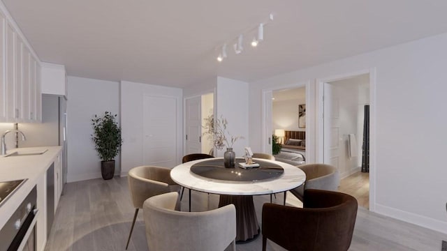 dining space with sink and light wood-type flooring