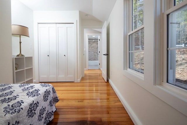 bedroom featuring a closet, baseboards, and wood finished floors