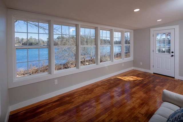 unfurnished sunroom featuring a water view and plenty of natural light