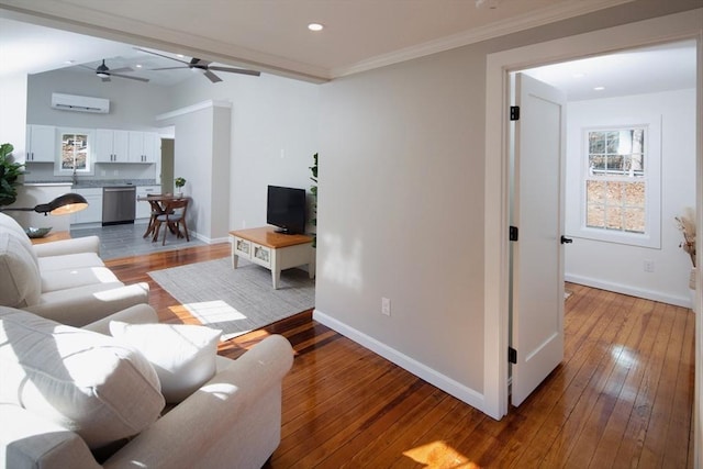 living room with baseboards, wood-type flooring, and an AC wall unit