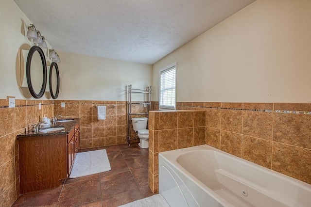 bathroom with tile walls, wainscoting, a garden tub, toilet, and double vanity