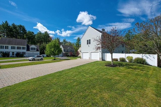 view of side of property featuring a garage and decorative driveway