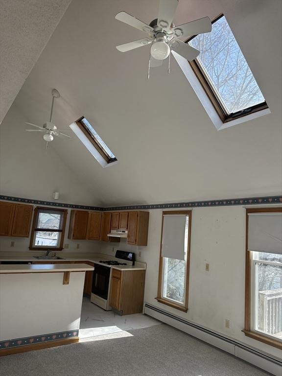 kitchen featuring a skylight, a baseboard radiator, sink, gas range gas stove, and light carpet