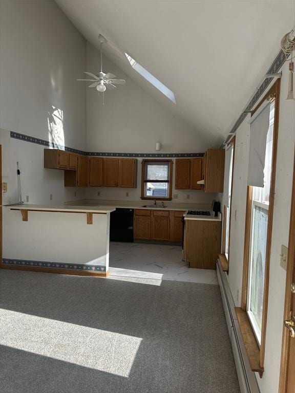 kitchen with dishwasher, a skylight, a kitchen bar, light colored carpet, and kitchen peninsula