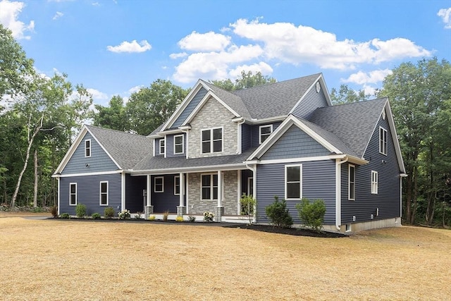 62 Bolton Rd Oakmont, Unit Oakmont, Westminster, MA 01473 - craftsman house featuring a porch, stone siding, a shingled roof, and a front yard