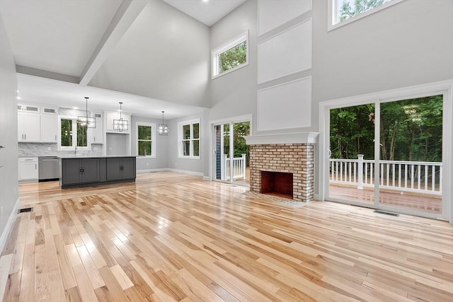62 Bolton Rd Oakmont, Unit Oakmont, Westminster, MA 01473 - unfurnished living room with light wood-type flooring, a sink, a high ceiling, healthy amount of natural light, and baseboards
