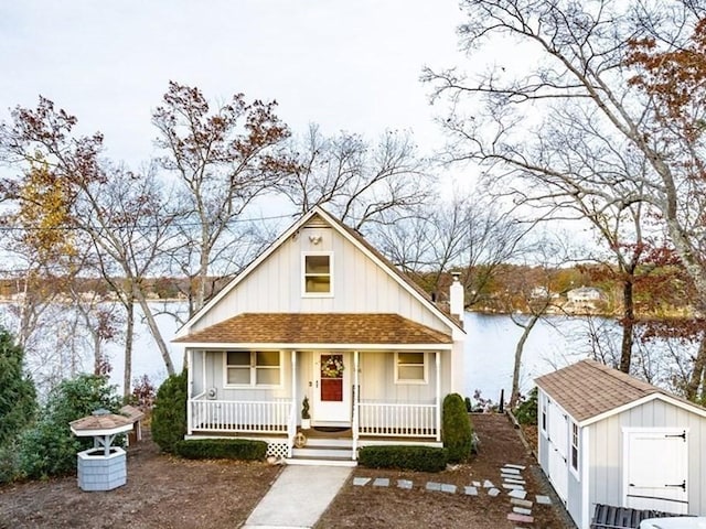 24 Shore Rd, Southwick, MA 01077 - bungalow featuring a storage shed, covered porch, roof with shingles, an outbuilding, and a chimney