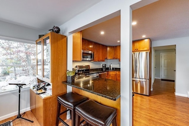 24 Shore Rd, Southwick, MA 01077 - kitchen featuring stainless steel appliances, light wood-type flooring, dark stone countertops, baseboards, and recessed lighting
