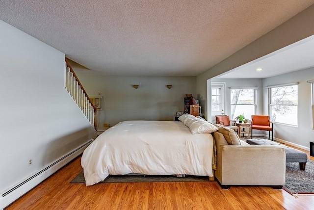 24 Shore Rd, Southwick, MA 01077 - bedroom featuring a baseboard heating unit, light wood-style flooring, a textured ceiling, and recessed lighting