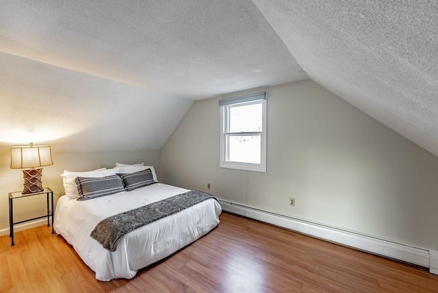24 Shore Rd, Southwick, MA 01077 - bedroom featuring light wood finished floors, a baseboard heating unit, a textured ceiling, and lofted ceiling