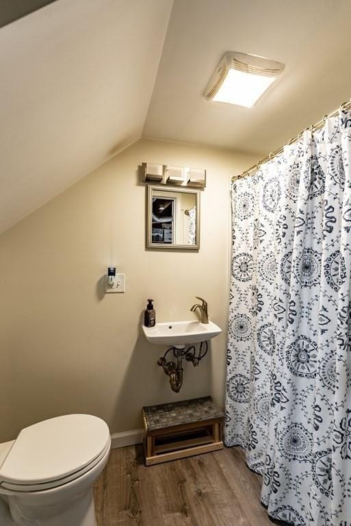 24 Shore Rd, Southwick, MA 01077 - full bathroom featuring wood finished floors, toilet, vaulted ceiling, baseboards, and curtained shower