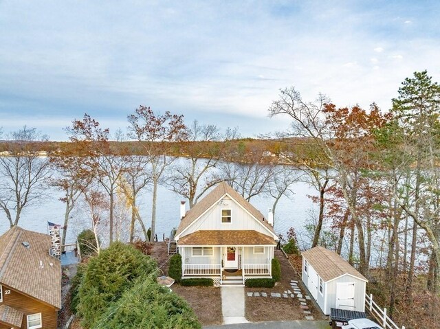 24 Shore Rd, Southwick, MA 01077 - view of front of house featuring a shed, covered porch, a chimney, and an outbuilding