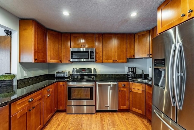 24 Shore Rd, Southwick, MA 01077 - kitchen featuring appliances with stainless steel finishes, a sink, brown cabinetry, light wood finished floors, and recessed lighting