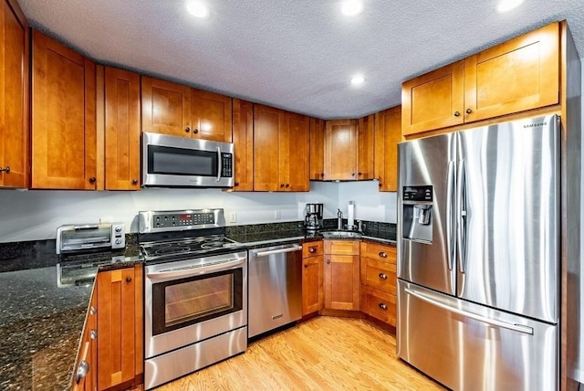 24 Shore Rd, Southwick, MA 01077 - kitchen with stainless steel appliances, brown cabinetry, a sink, recessed lighting, and a textured ceiling