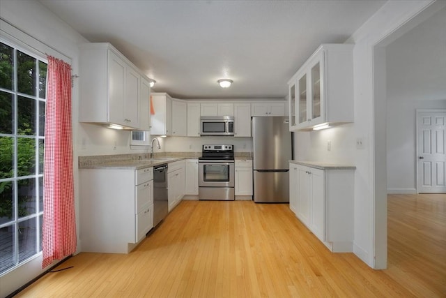 25 Liam Ln, Barnstable, MA 02632 - kitchen with appliances with stainless steel finishes, light wood finished floors, light countertops, glass insert cabinets, and white cabinetry