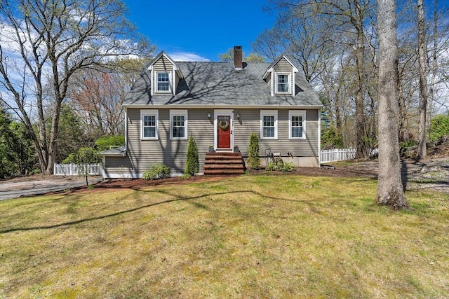 cape cod-style house featuring fence, a chimney, a shingled roof, and a front lawn