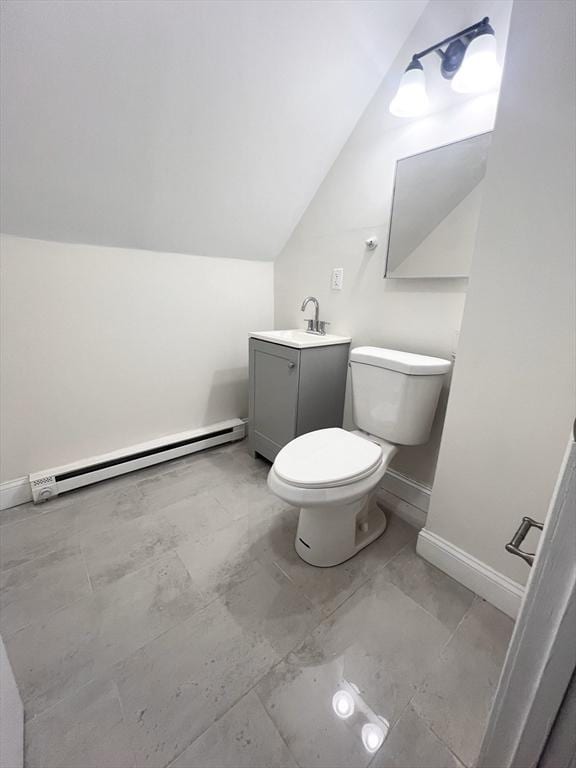 bathroom with vanity, lofted ceiling, toilet, and a baseboard heating unit