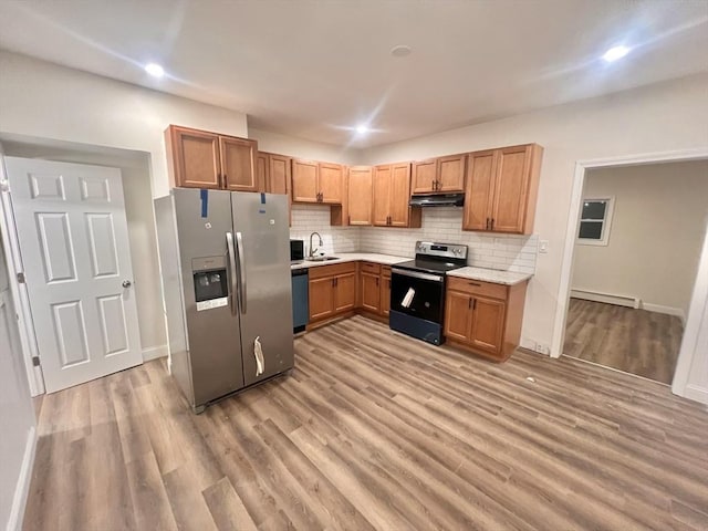 kitchen with light hardwood / wood-style floors, sink, baseboard heating, and stainless steel appliances